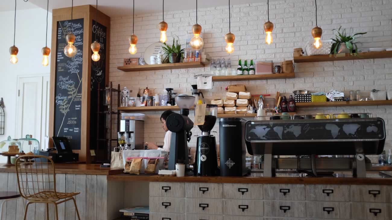 Warm café interior with pendant lights and a coffee counter